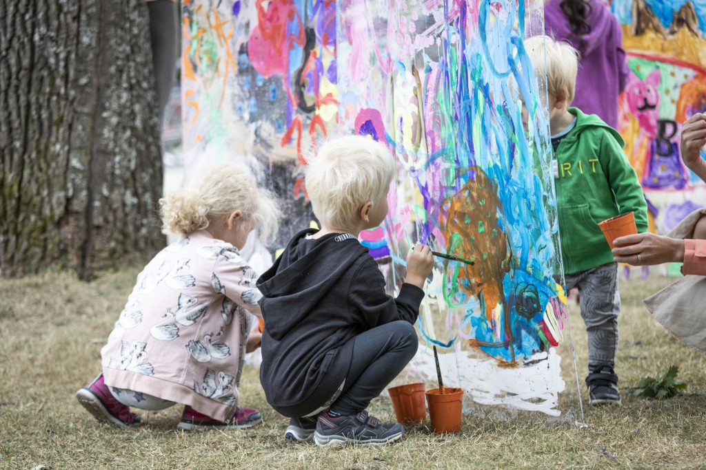 Lapset maalaamassa ulkona.